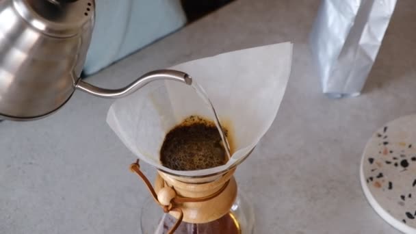 コーヒーで満たされたペーパーフィルターにお湯を注ぐバリスタは ケモックスコーヒーを準備します コーヒー醸造法 — ストック動画