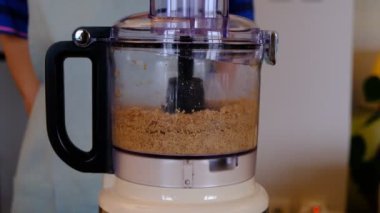 Yiyecek işlemcisinde badem yağı yapıyorum. Vejetaryen yemeği hazırlıyorum..