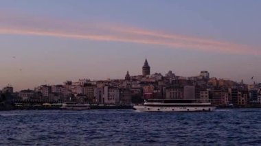 İstanbul, Türkiye, 02 / 03 / 2020 - Galata Kulesi, Galata Köprüsü ve Golden Horn 'da büyülü saatlerde günbatımı. Altın Boynuz büyük bir kentsel su yolu ve İstanbul 'da Boğaz' ın birincil körfezi. Martılar ve tekneler geçiyor. İstanbul titreşimleri gösteriliyor