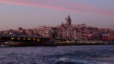İstanbul, Türkiye, 02 / 03 / 2020 - Galata Kulesi, Galata Köprüsü ve Golden Horn 'da büyülü saatlerde günbatımı. Altın Boynuz büyük bir kentsel su yolu ve İstanbul 'da Boğaz' ın birincil körfezi. Martılar ve tekneler geçiyor. İstanbul titreşimleri gösteriliyor