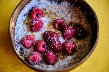 Ahududu, hindistan cevizi gevreği ve akçaağaç şurubuyla kaplanmış teff ve kinoa ile yoğurt. Ev yapımı sağlıklı atıştırmalık