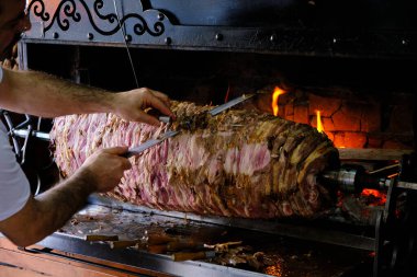 İstanbul, Türkiye / Şubat 2020 - Cag Kebap, Geleneksel Türk Kebap şef tarafından hazırlanıyor. Servis için kebap dilimliyorum..
