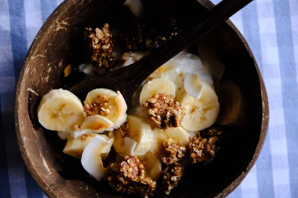 带有香蕉片 椰子和麦片的酸奶 椰子碗中的健康小吃 — 图库照片