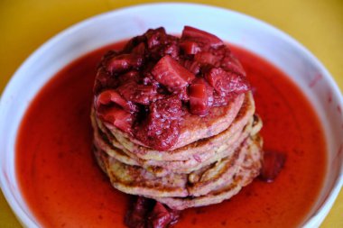 Ev yapımı çilek soslu bir yığın vejetaryen krep. Lezzetli ve sağlıklı ev yapımı kahvaltı..