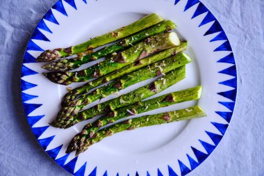 Baharat ve zeytinyağıyla pişirilmiş kuşkonmaz.