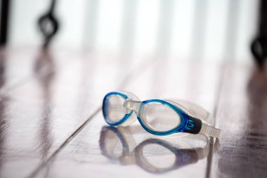 Mavi Yüzme gözlüğü izole kopya spac ile kahverengi ahşap sandalye