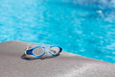 Mavi Yüzme gözlüğü izole kahverengi kumaş sandalyede kopya ile sp