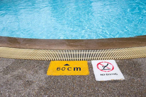 Warning and depth sign at swimming pool for children Stock Photo