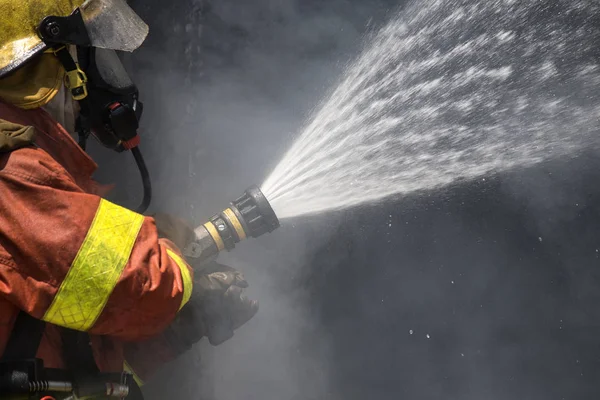 Firefighter water spray by high pressure fire hose — Stock Photo, Image