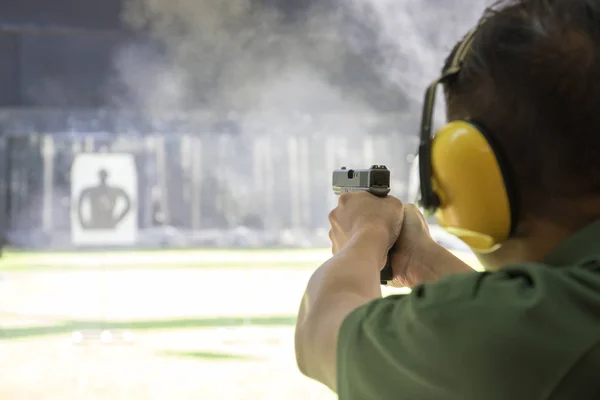 Man afvuren automatisch pistool naar doel in het ontspruiten van waaier — Stockfoto