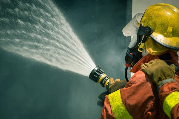 Spruzzi d'acqua del vigile del fuoco dal tubo antincendio ad alta pressione — Foto Stock