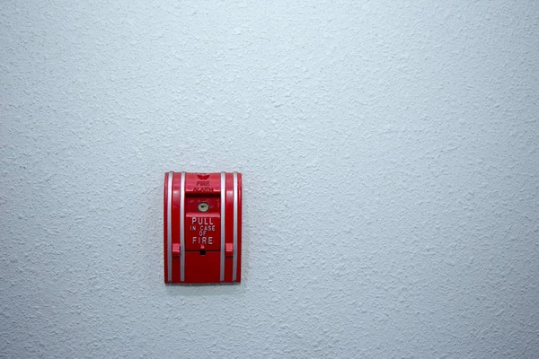 Red fire alarm switch on blue wall background — Stock Photo, Image