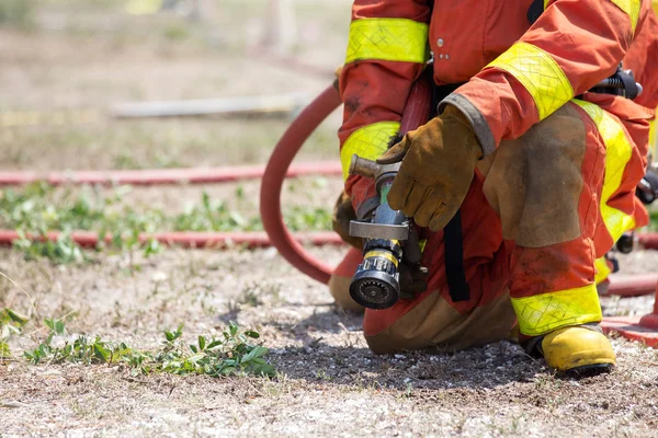 Feuerwehrleute stehen mit Feuerwehrschlauch für Löscheinsatz bereit — Stockfoto