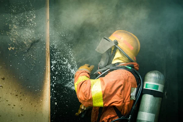 Uno spruzzo d'acqua di pompiere da ugello ad alta pressione per sparare — Foto Stock