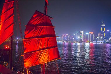 Hong Kong, Çin - 9 Aralık 2017. Çinlilerin kırmızı Simgesel Yapı ile önemsiz tekne ve Victoria Limanı gece sahne sis arka plan ile içinde Hong Kong Kış Festivali yelken. Hong Kong dünyanın en neşeli Christmases biridir