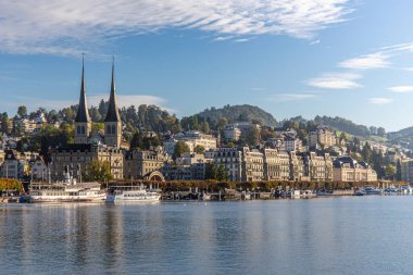 Luzern, İsviçre - Ekim 1,2019 - Luzern ve Reuss nehrinin tarihi binası ve mavi gökyüzü arka planıyla manzarası. Lucerne, İsviçre 'nin orta kesimindeki en kalabalık kasabadır..