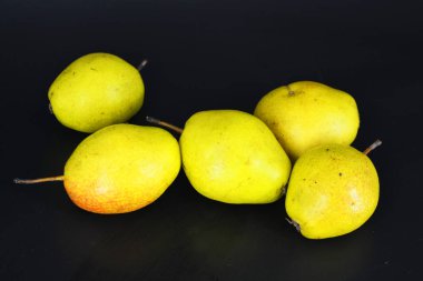 Siyah plastik arka planda parlak, lezzetli yeşil, kırmızı ve sarı armutlar bulunur. Düzgün beslenme, her gün için sağlıklı taze meyveler..