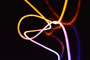 Sarı ve mavi ışık kablosu, farklı ışık iletimi, ışık spektrumu ve ışık efektleri içeren bir ışık kılavuzu kablosu, kaotik bir durumda ve siyah parlak bir arka planda ışık yansıması var..