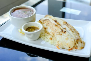 Pirinç ve sarımsak soslu ızgara Pangasius, püre ile servis yap.