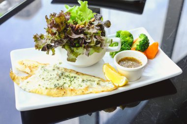 Beyaz krema soslu ızgara Pangasius, taze salatayla servis et.
