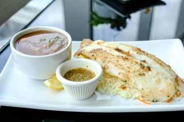 Pirinç ve sarımsak soslu ızgara Pangasius, püre ile servis yap.