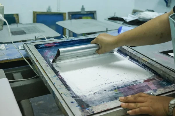 Hand pressing silk-screen printing, close up view.