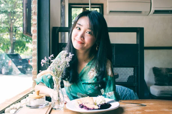 Hermosa mujer asiática sentada en el café con un plato de desser — Foto de Stock