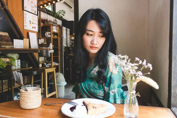 Hermosa mujer asiática sentada en el café con un plato de desser — Foto de Stock