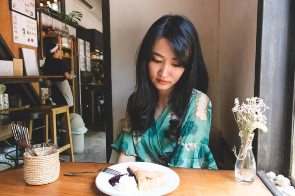 Hermosa mujer asiática sentada en el café con un plato de desser — Foto de Stock