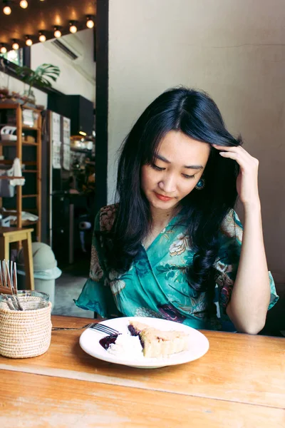 Hermosa mujer asiática sentada en el café con un plato de desser — Foto de Stock