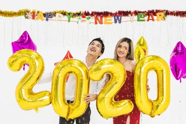 Pareja joven celebrando año nuevo juntos, la celebración de 2020 globo —  Fotos de Stock