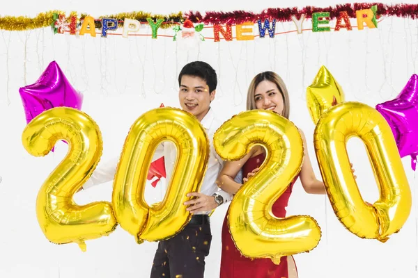 Pareja joven celebrando año nuevo juntos, la celebración de 2020 globo —  Fotos de Stock