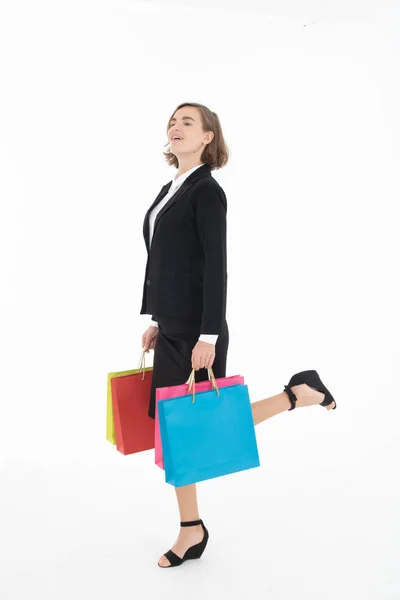 Portret van een jonge zakenvrouw met boodschappentassen op wit — Stockfoto