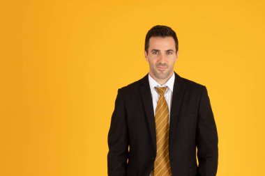 Sarı arka planda kendinden emin iş adamının portresi.