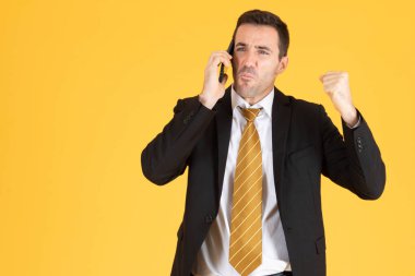 Sarı arka planda akıllı telefon kullanan mutlu iş adamının portresi