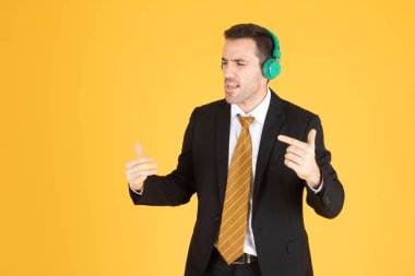 Sarı torbaya kulaklık takan kendine güvenen iş adamının portresi
