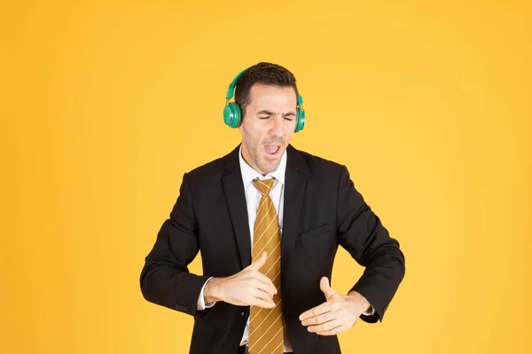 Portret pewnego siebie biznesmena używającego słuchawki na żółtej bac — Zdjęcie stockowe