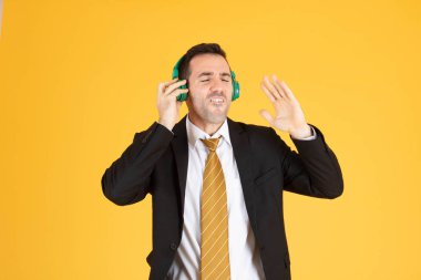 Sarı torbaya kulaklık takan kendine güvenen iş adamının portresi