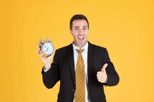 Retrato de un hombre de negocios guapo sosteniendo el reloj con los pulgares hacia arriba — Foto de Stock
