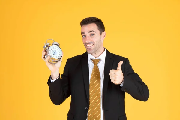 Portrét pohledného obchodníka držícího hodiny s palci nahoru — Stock fotografie
