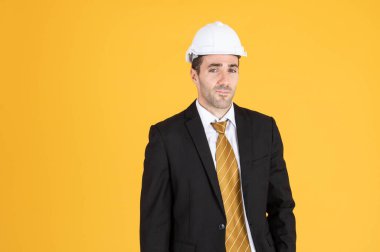 Genç yakışıklı işadamı takım elbise giyer ve miğfer takar