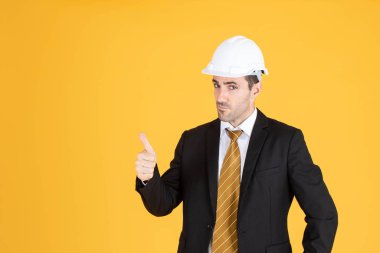 Genç yakışıklı işadamı takım elbise giyer ve miğfer takar