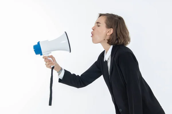 Jonge zakenvrouw schreeuwt door een megafoon op wit is — Stockfoto