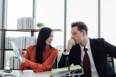 İki iş adamları konusunda konuşurken bir ofiste çalışmak.