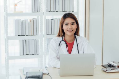 Masasında çalışan genç Asyalı doktor..