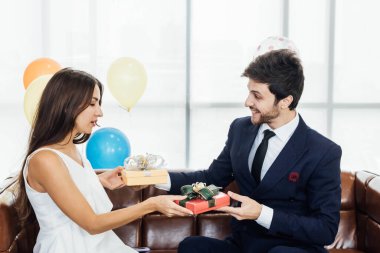 Genç çift yeni yılı birlikte kutluyor, birbirlerine hediyelerini veriyorlar..