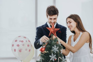 Genç Asyalı çiftin evde Noel ağacı süslemesi, tatil konsepti..