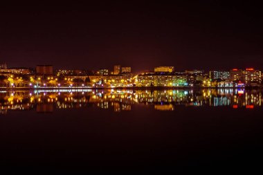 Night city reflected in the water. Ukraine, Ternopil clipart