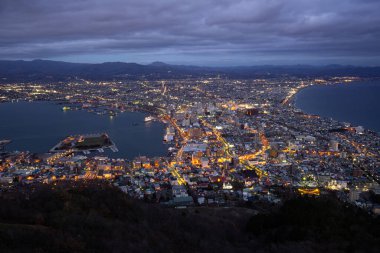 Hakodate, Japan - 30Nov2019: Million Dollar View from Mount Hakodate, take the ropeway from the foothill to the summit. The contrast of the twinkling city lights and the pitch blackness of the ocean is indescribably beautiful. clipart