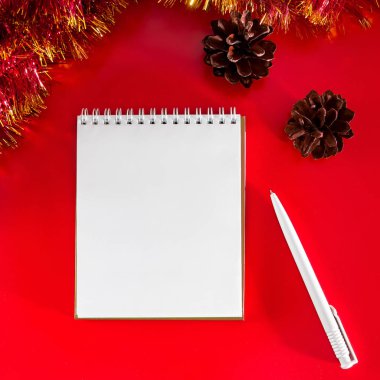 Noel dekorasyonunun arka planında boş defter ve kalem